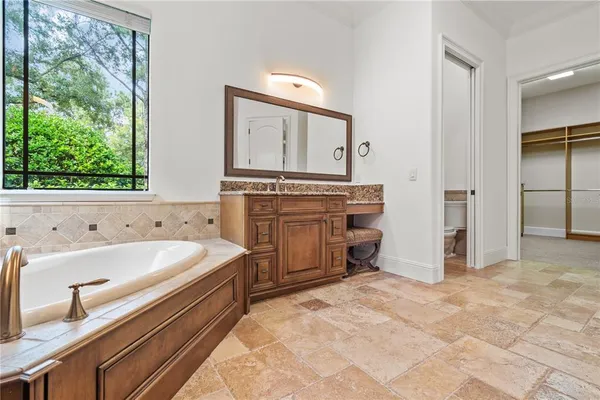 a white bath tub sitting in a bathroom next to a window