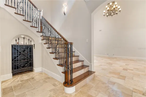 a view of hallway with wooden floor and a chandelier