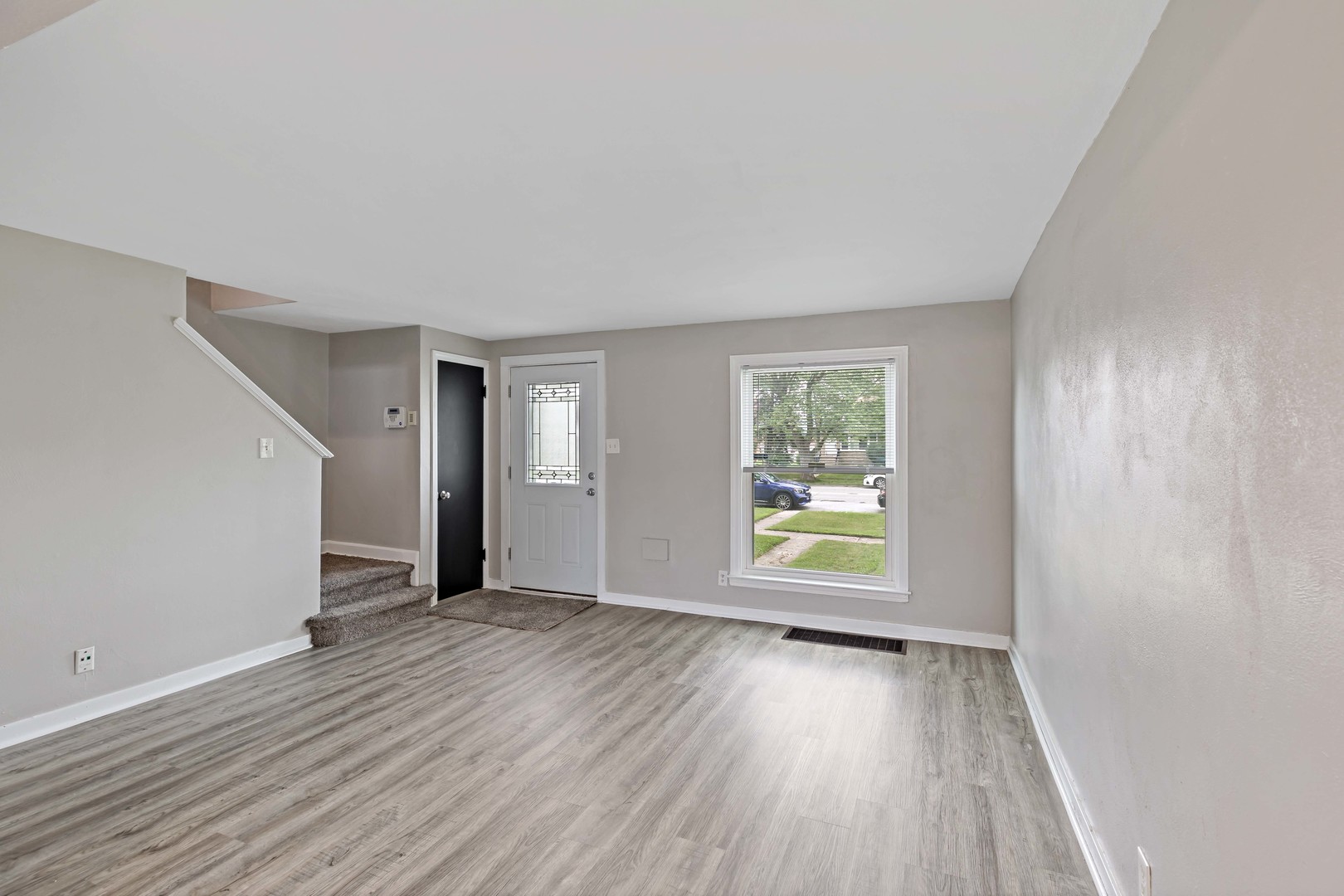 1404 Wentworth Avenue, Unit 1 Calumet City, IL 60409 - Photo 2 of 14 an empty room with wooden floor and windows