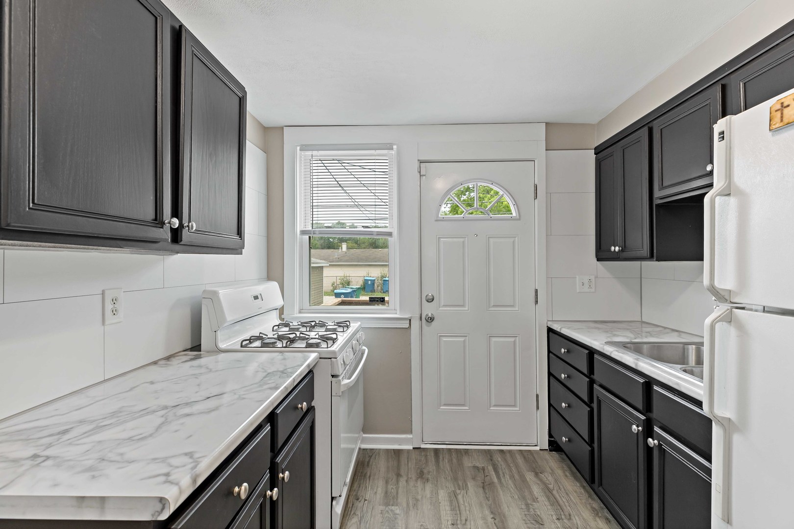 1404 Wentworth Avenue, Unit 1 Calumet City, IL 60409 - Photo 5 of 14 a kitchen with stainless steel appliances granite countertop a sink stove and cabinets