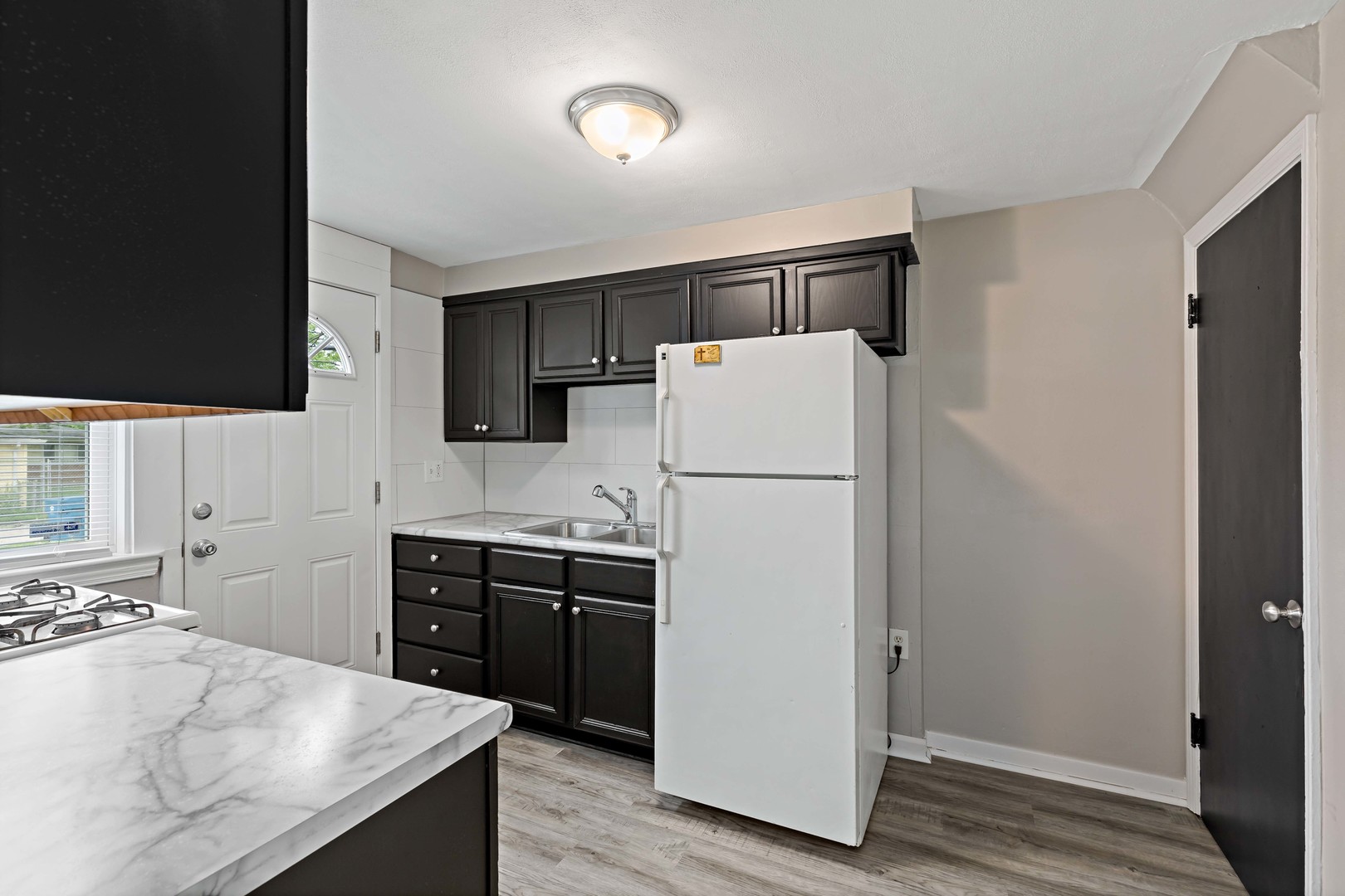 1404 Wentworth Avenue, Unit 1 Calumet City, IL 60409 - Photo 6 of 14 a kitchen with a sink a refrigerator and a stove top oven