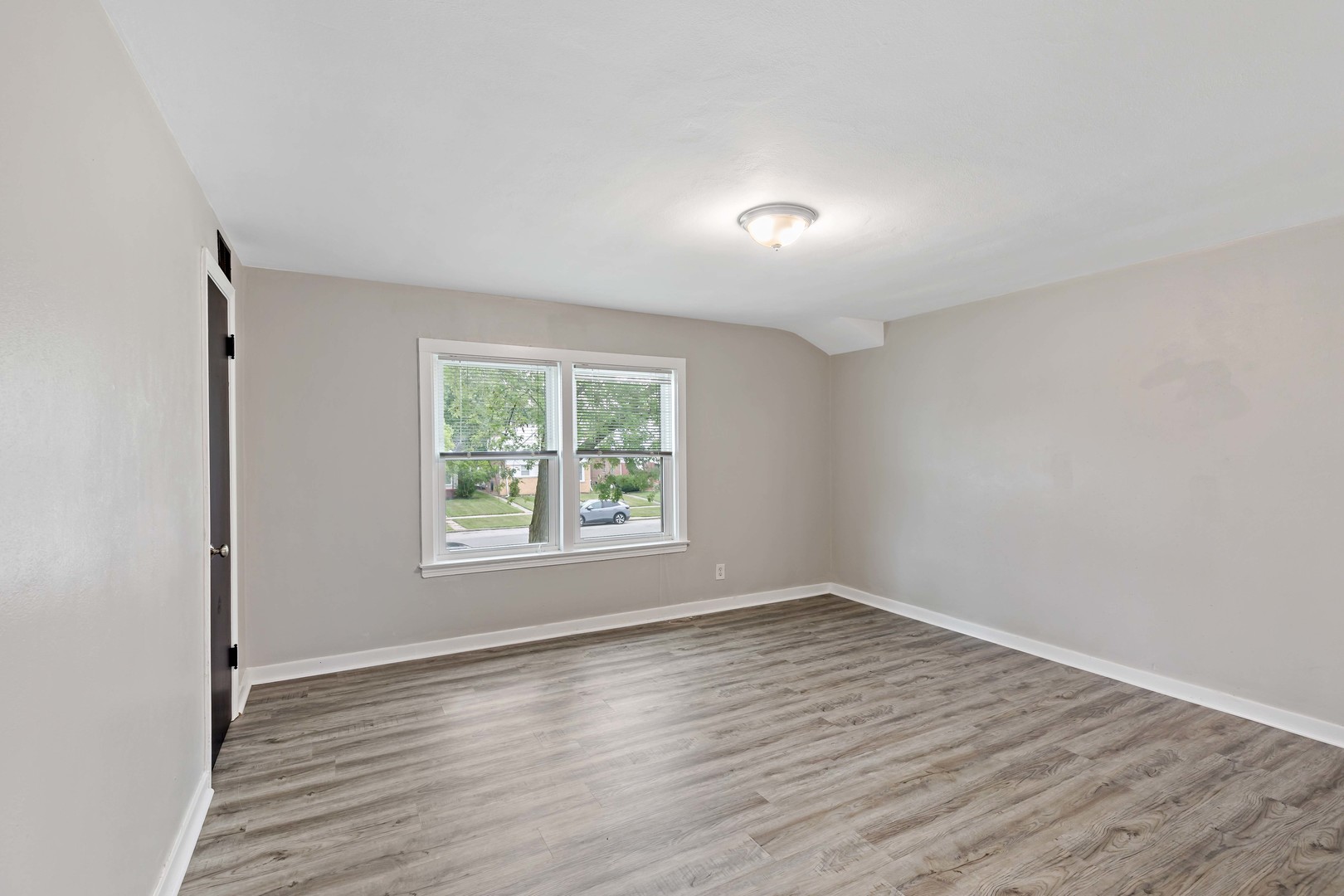 1404 Wentworth Avenue, Unit 1 Calumet City, IL 60409 - Photo 7 of 14 an empty room with wooden floor and windows
