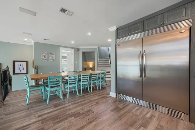 a kitchen with kitchen island a dining table chairs cabinets and stainless steel appliances