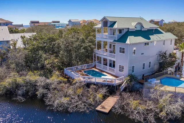 a kitchen with stainless steel appliances a dining table chairs and wooden floor