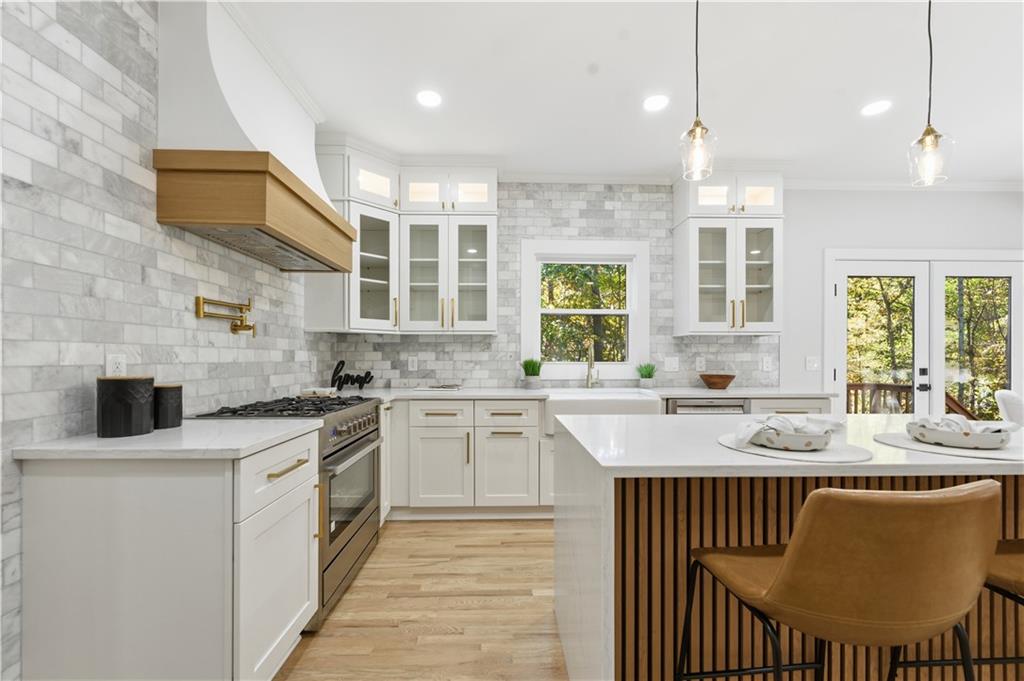 435 Lakepoint Trace Canton, GA 30114 - Photo 11 of 80 a kitchen with stainless steel appliances granite countertop a stove a sink dishwasher a oven and a dining table with wooden cabinet
