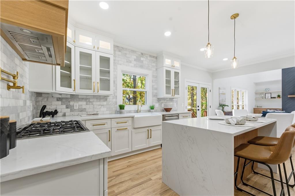 435 Lakepoint Trace Canton, GA 30114 - Photo 10 of 80 a kitchen with a stove a sink a kitchen island with a dining table and chairs