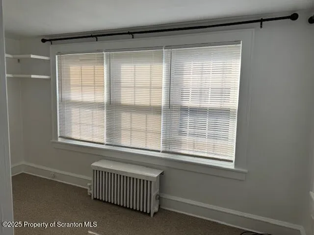 a view of a bedroom with a chair and a window