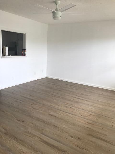 324 Mansfield H Boca Raton, FL 33434 - Photo 3 of 10 a view of an empty room with wooden floor and a fireplace