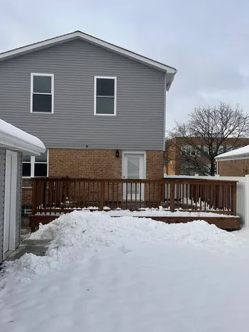 a view of house with yard and snow in the background