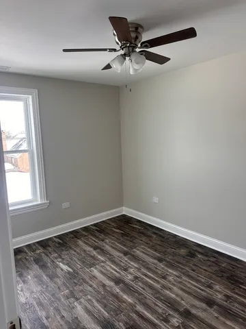 a view of a room with wooden floor and a window