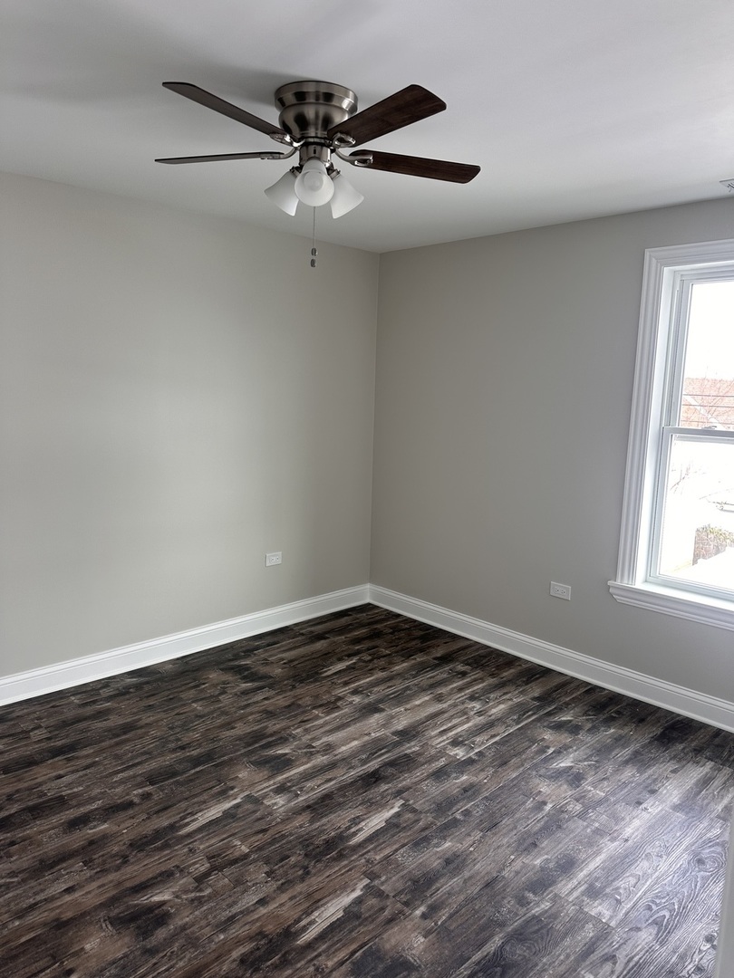 8017 South Kostner Avenue Chicago, IL 60652 - Photo 9 of 17 a view of an empty room with a window and wooden floor