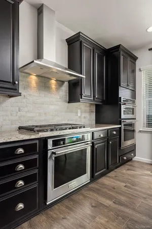 a kitchen with stainless steel appliances granite countertop a stove microwave and cabinets
