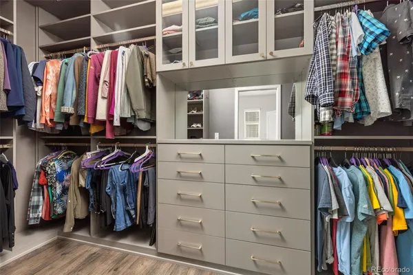 a view of walk in closet with clothes and shoes
