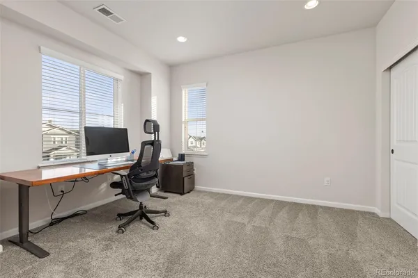 a view of a workspace with furniture and a window