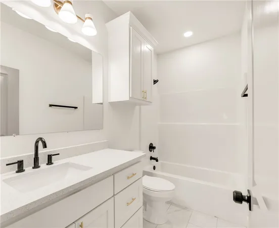 a bathroom with a bathtub shower sink vanity mirror and toilet