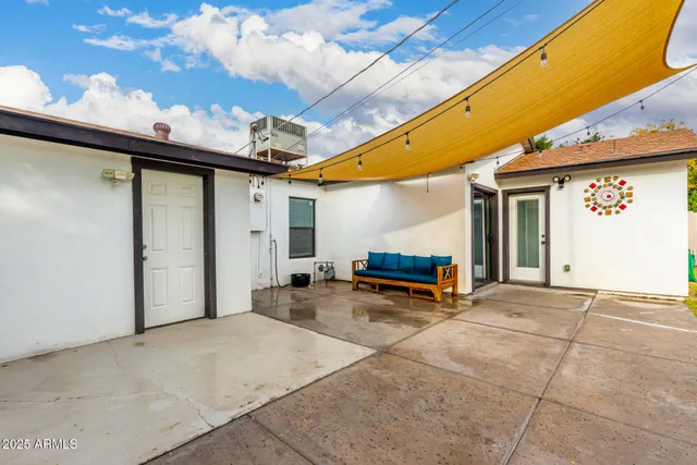 a view of a patio with table and chairs under an umbrella