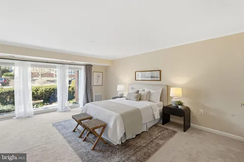 a bedroom with a bed and large window