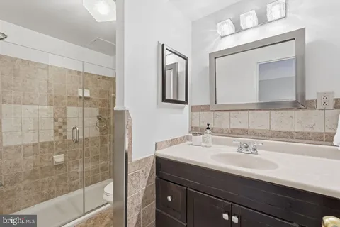 a bathroom with a sink mirror and shower