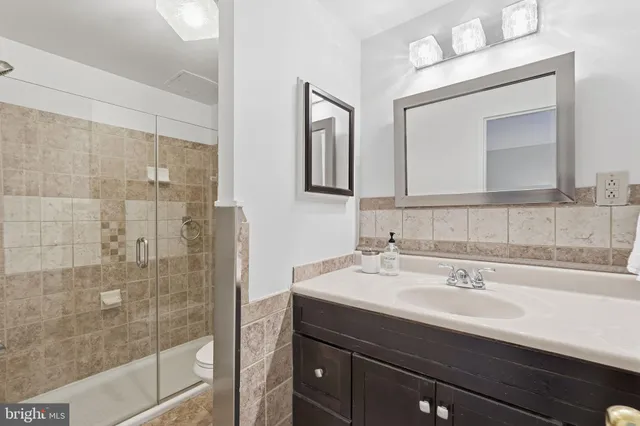 a bathroom with a sink mirror and shower