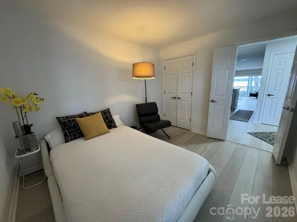 a bedroom with bed and wooden floor