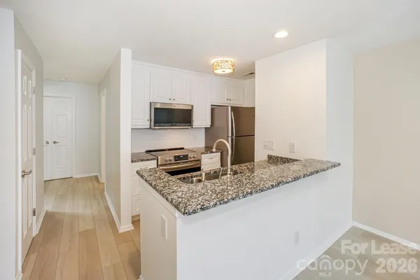 a kitchen with kitchen island granite countertop a sink stove and refrigerator