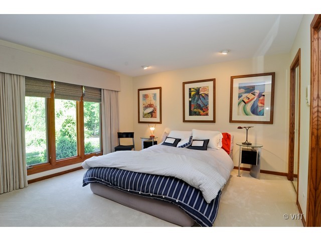 1507 Appleby Road Inverness, IL 60067 - Photo 18 of 25 a bedroom with a bed painting on the wall and a large window