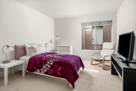 a bedroom with a bed and a flat screen tv