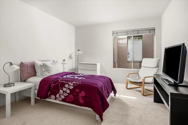 a bedroom with a bed and a flat screen tv