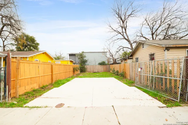 a view of a backyard with wooden fence