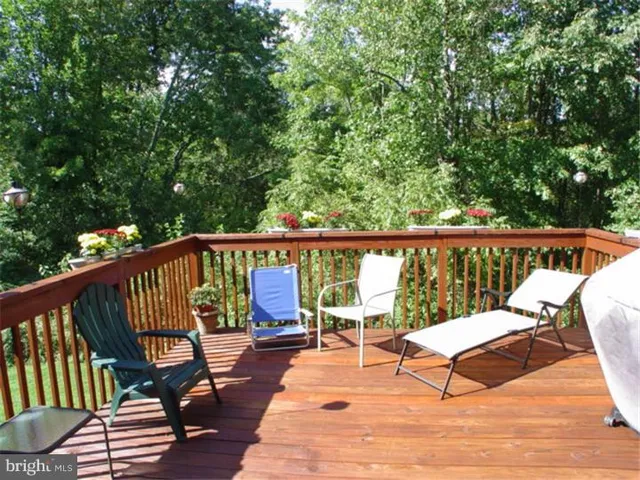 a balcony with wooden floor and outdoor seating