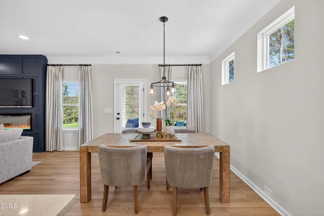 a dining room with furniture a chandelier and wooden floor