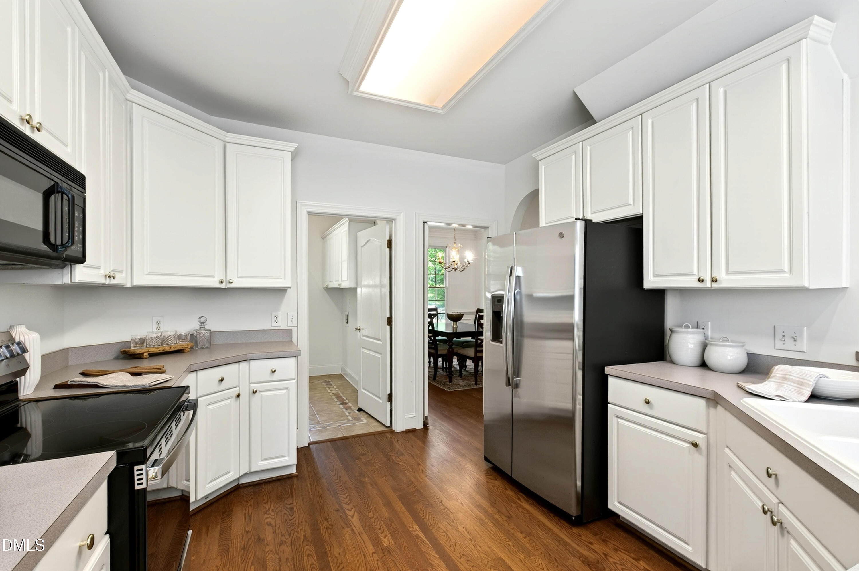2721 Glassman Lane Raleigh, NC 27606 - Photo 31 of 74 a kitchen with white cabinets and stainless steel appliances