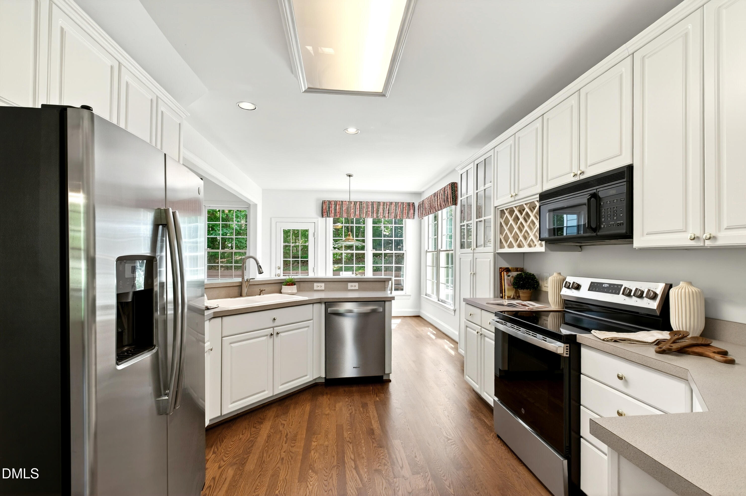 2721 Glassman Lane Raleigh, NC 27606 - Photo 34 of 74 a kitchen with stainless steel appliances a stove a sink a refrigerator a microwave a sink and cabinets
