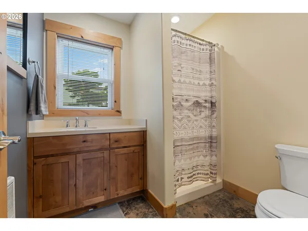 a bathroom with a sink a toilet and shower