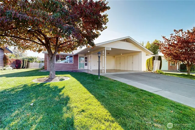 a front view of a house with a yard and trees