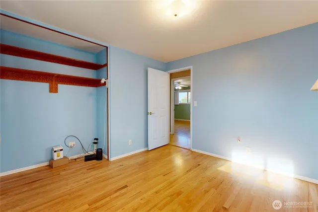 a room with a bed and wooden floor