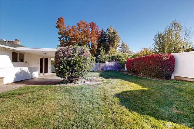 a front view of a house with a yard and trees