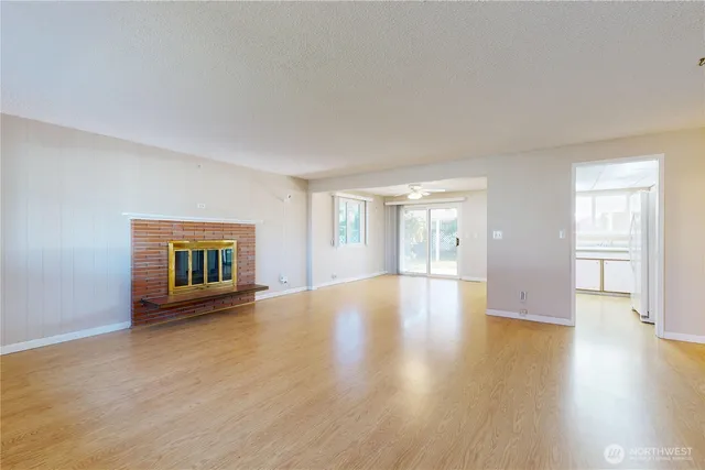 a view of an empty room with window and wooden floor