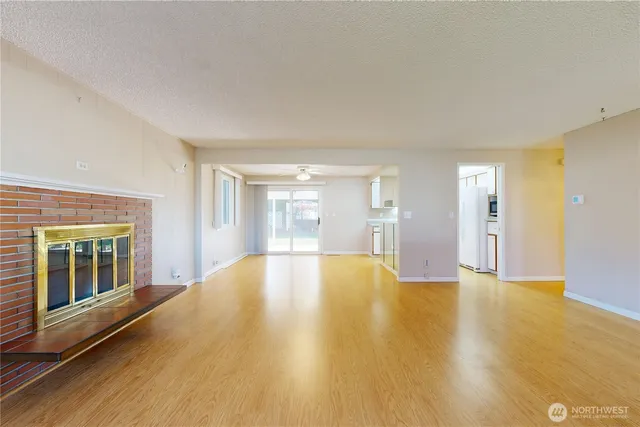 a view of an empty room with window and wooden floor