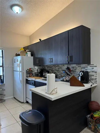 a kitchen with stainless steel appliances a sink dishwasher stove and refrigerator with wooden cabinets