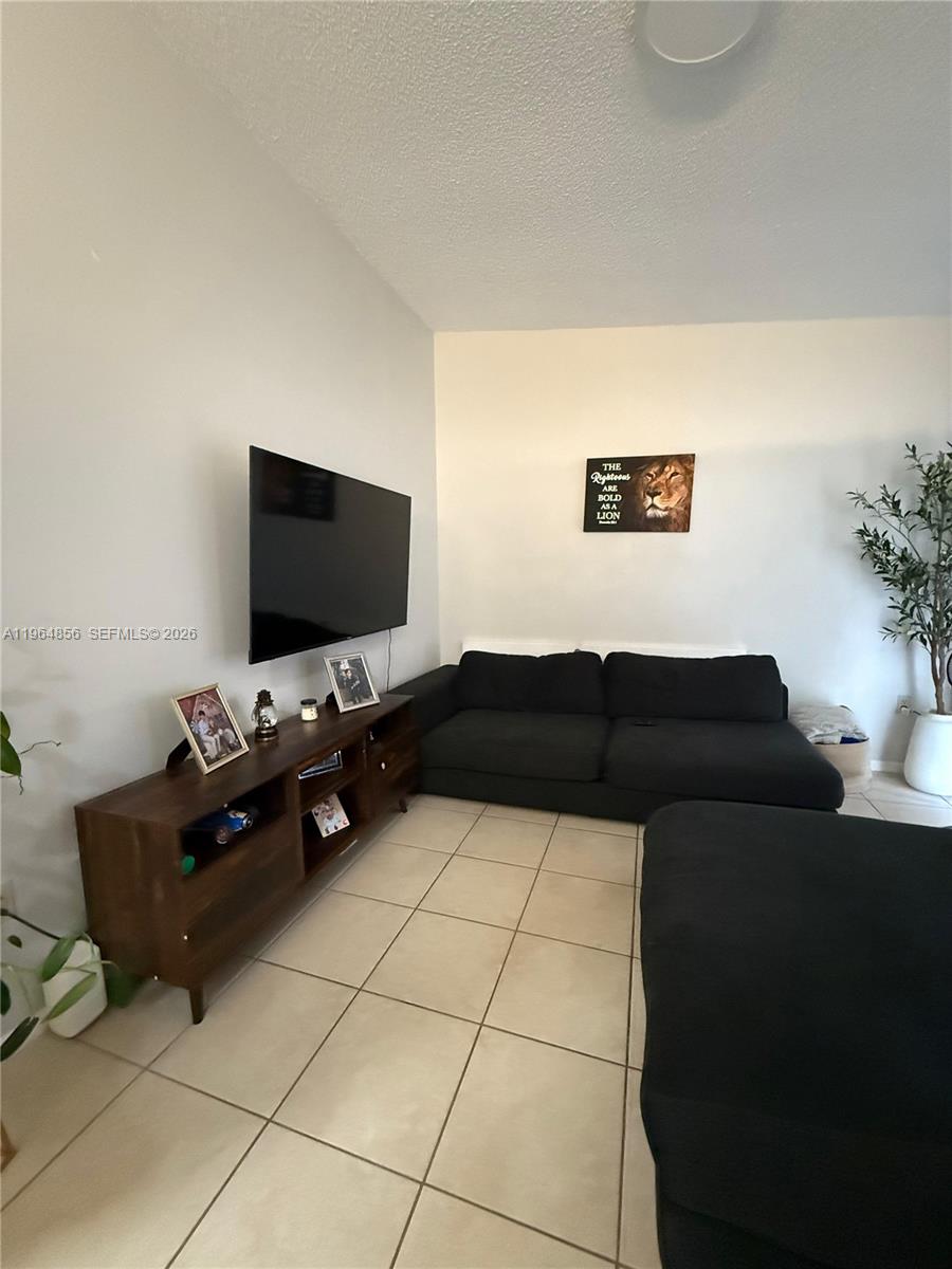 7440 Southwest 153rd Court, Unit 2014 Miami, FL 33193 - Photo 8 of 25 a living room with furniture and a flat screen tv