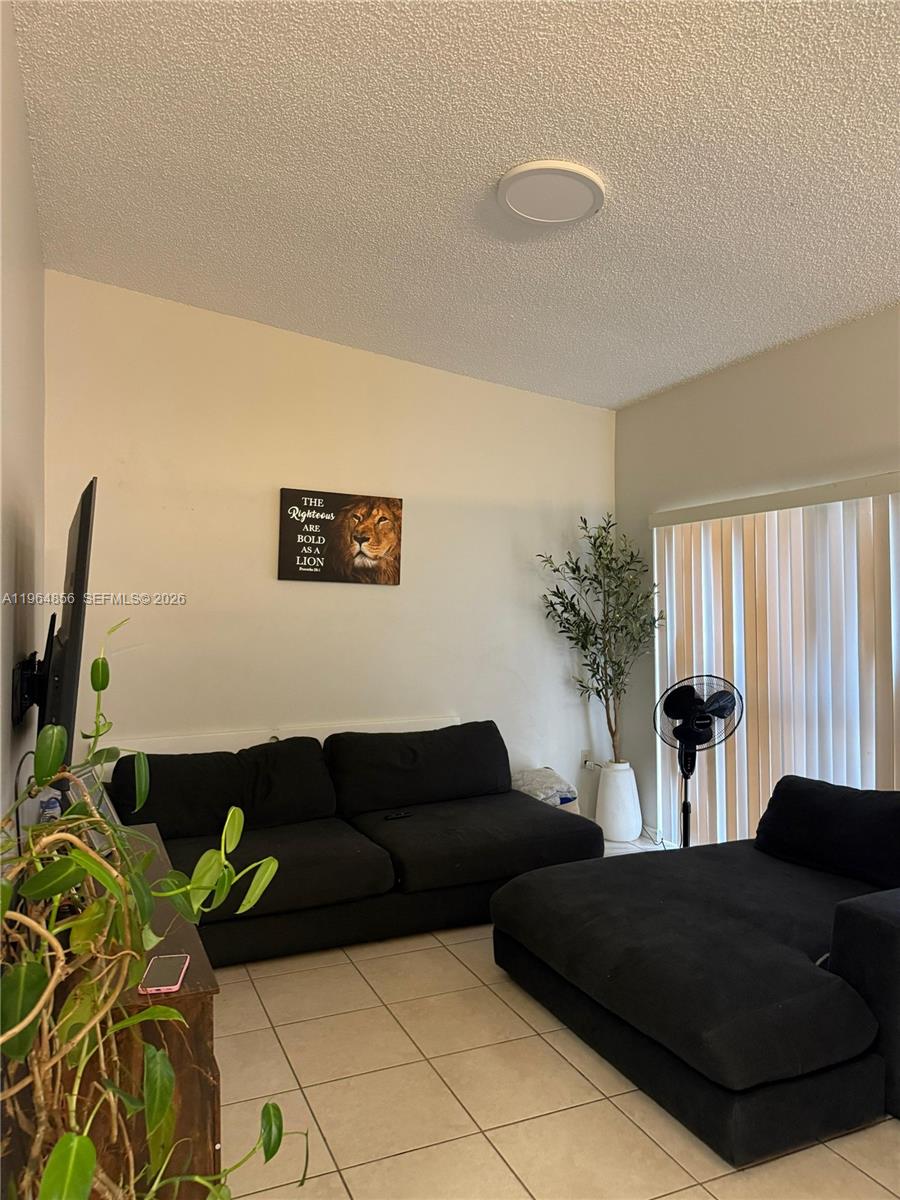 7440 Southwest 153rd Court, Unit 2014 Miami, FL 33193 - Photo 9 of 25 a living room with furniture and a flat screen tv