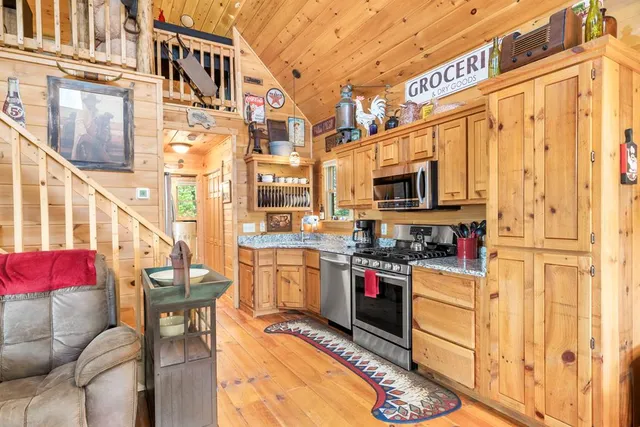 a kitchen with stainless steel appliances kitchen island granite countertop a stove and a refrigerator