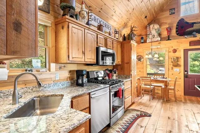 a kitchen with stainless steel appliances granite countertop a stove a sink and a microwave