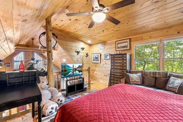 a bedroom with a bed dresser and a large window