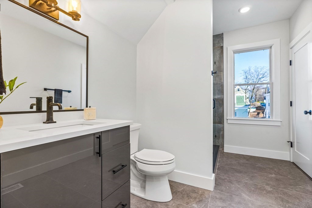14 Hillside Park, Unit 6 Somerville, MA 02143 - Photo 28 of 32 a bathroom with a toilet a sink and mirror