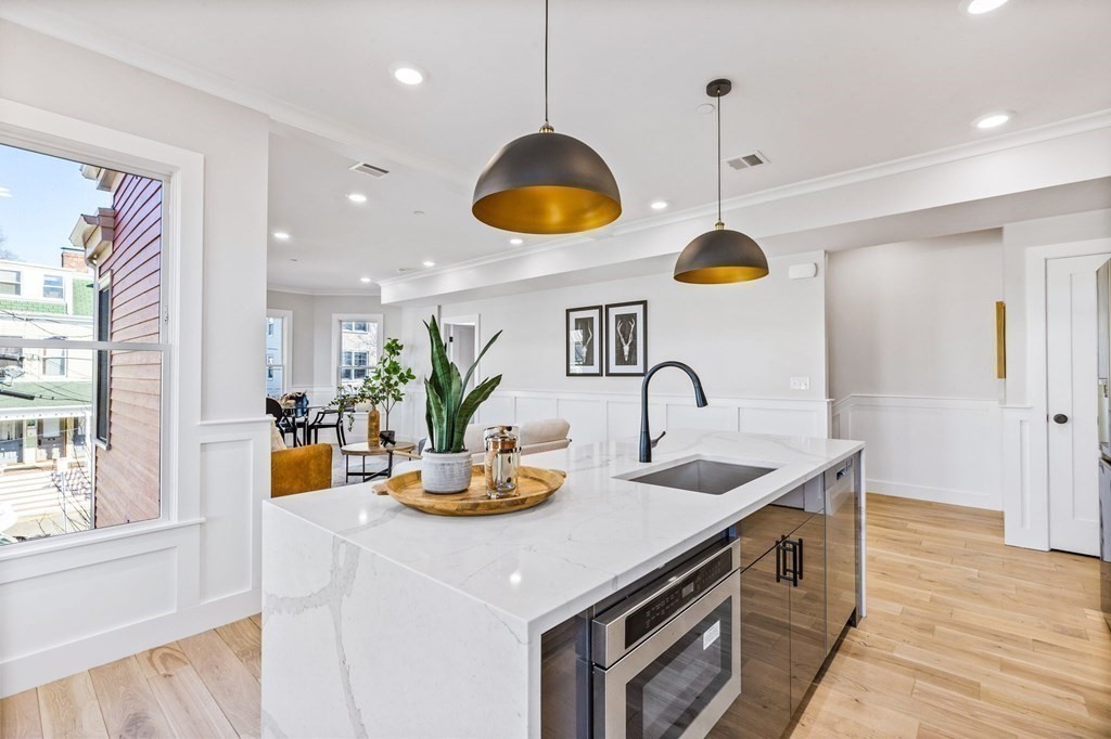 14 Hillside Park, Unit 6 Somerville, MA 02143 - Photo 4 of 32 a kitchen with stainless steel appliances granite countertop a sink a stove and a wooden floors