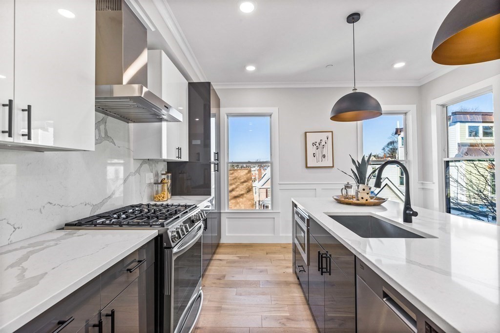 14 Hillside Park, Unit 6 Somerville, MA 02143 - Photo 5 of 32 a kitchen with stainless steel appliances a sink a stove and a wooden floors