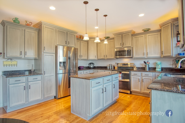 S643 Robbins Street Winfield, IL 60190 - Photo 6 of 40 a kitchen with stainless steel appliances granite countertop a refrigerator a stove and white cabinets