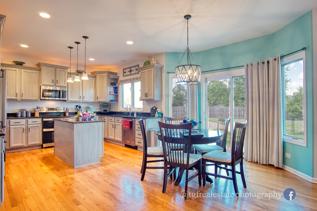 S643 Robbins Street Winfield, IL 60190 - Photo 7 of 40 a view of a dining room and livingroom with furniture wooden floor a chandelier